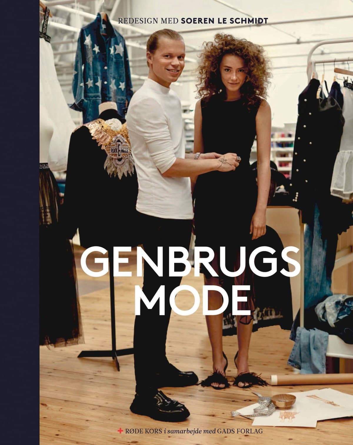 Cover of the Danish Red Cross book Genbrugsmode: two people in a design studio among clothing rails